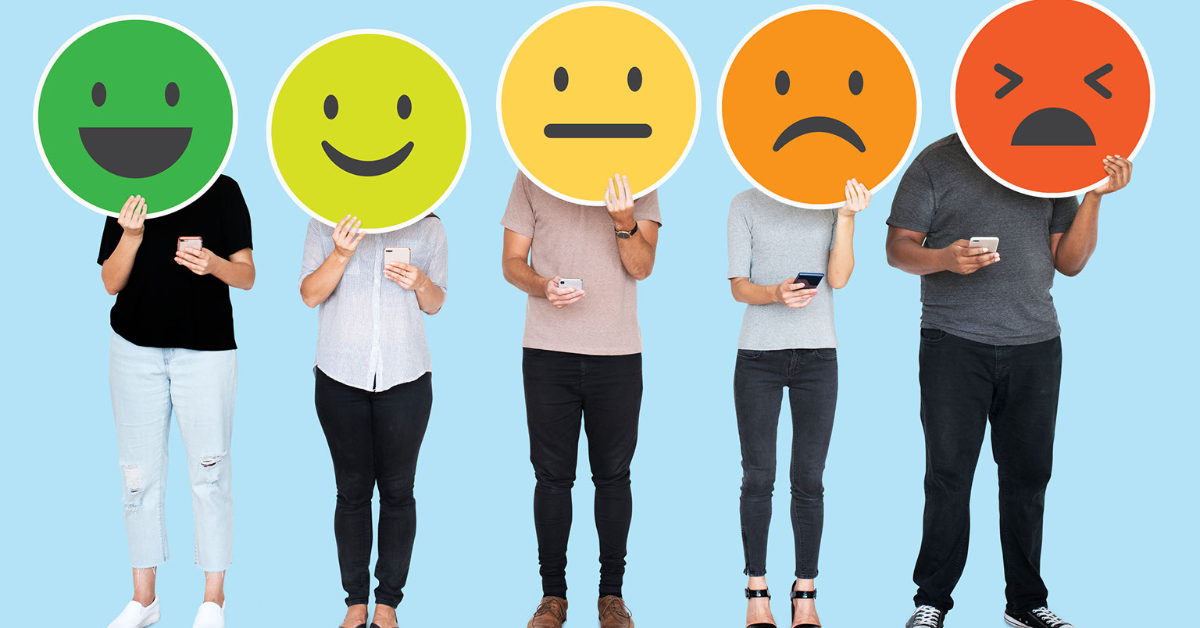 Five people holding large emoji faces ranging from happy to angry in front of their own.