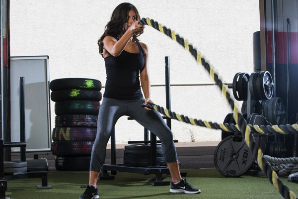 Woman exercising on an elliptical trainer at a gym.