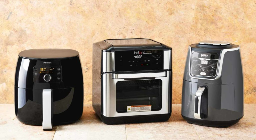 Three modern kitchen appliances, including air fryers, lined up on a counter.