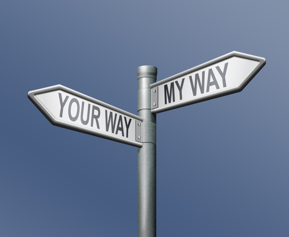 Street signs "YOUR WAY" and "MY WAY" against a clear blue sky.